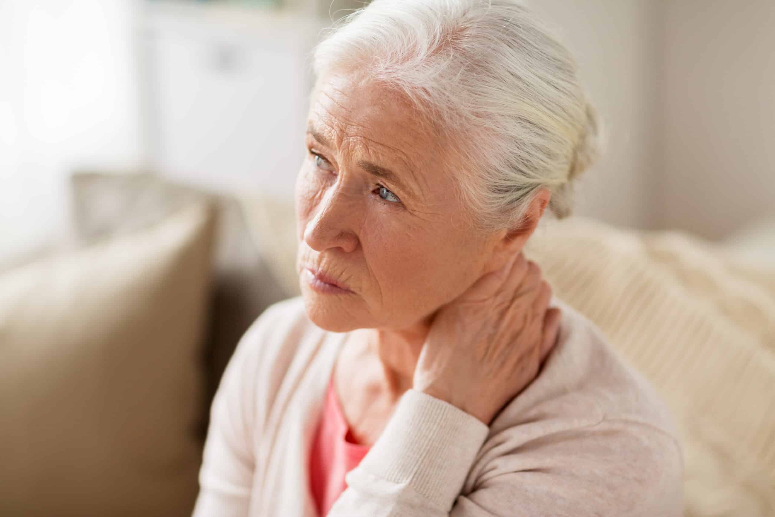 senior woman suffering from neck pain at home senior woman suffering from neck pain at home